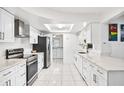 Spacious white kitchen featuring stainless steel appliances and ample countertop space at 11225 59Th Ave, Seminole, FL 33772