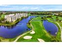 Scenic aerial view of a well-maintained golf course, lake, and nearby condo buildings at 1200 Country Club Dr # 5506, Largo, FL 33771
