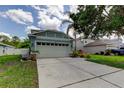 Features a two-car garage, framed by stone-based posts, and a concrete driveway at 12628 White Bluff Rd, Hudson, FL 34669