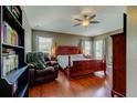 Bright main bedroom with rich hardwood floors, ceiling fan, and a luxurious, four-poster bed at 12628 White Bluff Rd, Hudson, FL 34669