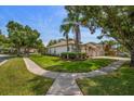 Well-maintained home exterior with mature trees, a three-car garage, and manicured landscaping at 12806 Castlemaine Dr, Tampa, FL 33626