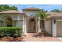 Inviting front entrance with a decorative archway, brick walkway, and manicured landscaping at 12806 Castlemaine Dr, Tampa, FL 33626