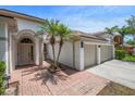 Welcoming front entrance featuring a brick walkway, archway, and a three-car garage at 12806 Castlemaine Dr, Tampa, FL 33626
