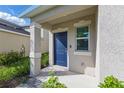 Inviting front entrance featuring a blue door with manicured landscaping at 13981 Lilac Sky Ter, Bradenton, FL 34211