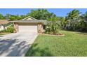 Charming single Gathering home featuring mature landscaping, well manicured lawn, and a two car garage at 15014 Winterwind Dr, Tampa, FL 33624