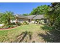 Landscaped front yard features vibrant greenery and manicured lawn surrounding this inviting home at 15014 Winterwind Dr, Tampa, FL 33624
