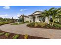 Inviting single-story home with brick driveway, lush landscaping, and welcoming covered porch at 16411 Sapphire Point Dr, Lakewood Ranch, FL 34211