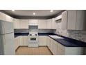 Well-equipped kitchen with white cabinets, modern appliances, blue countertops and tiled backsplash at 1708 E Genesee St, Tampa, FL 33610