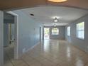 Spacious living room featuring tiled flooring, neutral paint, and natural light throughout at 1708 E Genesee St, Tampa, FL 33610