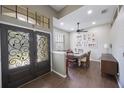 The dining room features decorative front doors, wood floors, and lots of natural light at 18520 Ambly Ln, Tampa, FL 33647
