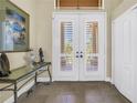 Elegant entryway with double doors, shutter blinds, and decorative console table at 2101 N Pointe Alexis Dr, Tarpon Springs, FL 34689