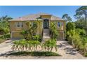 Elegant two-story home featuring a lush landscaped front yard with palm trees and a grand staircase at 2101 N Pointe Alexis Dr, Tarpon Springs, FL 34689