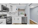 Bright kitchen featuring stainless steel appliances, marble backsplash, and view through the pass-through to the dining area at 2211 Belleair Rd # D3, Clearwater, FL 33764