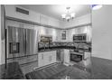 Modern kitchen featuring stainless steel appliances, mosaic backsplash, white cabinets and tile floors at 30 Turner St # 202, Clearwater, FL 33756