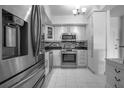 Modern kitchen featuring stainless steel appliances, mosaic backsplash, white cabinets and tile floors at 30 Turner St # 202, Clearwater, FL 33756