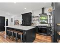 Stylish kitchen featuring a spacious island, white countertops, dark cabinets, and hardwood floors at 3221 W Oakellar Ave, Tampa, FL 33611