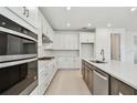 Modern kitchen featuring white cabinets, stainless steel appliances, and a quartz countertop island at 37202 Clinch Cir, Zephyrhills, FL 33540