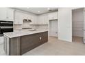 Bright kitchen featuring white cabinets, stainless steel appliances, and a center island with sink at 37202 Clinch Cir, Zephyrhills, FL 33540