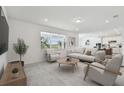 Bright living room with a large window and open floor plan, seamlessly connected to the kitchen with modern appliances at 37202 Clinch Cir, Zephyrhills, FL 33540
