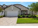 Inviting home showcasing a stone facade, well-manicured lawn, and an ample driveway leading to a spacious garage at 4220 Barletta Ct, Wesley Chapel, FL 33543
