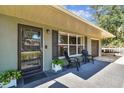 Cozy front porch with seating, complemented by a glass front door and well-manicured landscaping at 4610 W Mcelroy Ave, Tampa, FL 33611