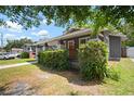 Charming bungalow featuring a cozy front porch, brick pillars and lush green hedge at 4803 Highland, Tampa, FL 33603