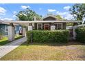 Charming bungalow featuring a cozy front porch, brick pillars and lush green hedge at 4803 Highland, Tampa, FL 33603