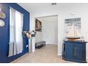 Stylish entryway with blue accent wall, tile flooring, modern decor, and a view into the home at 5068 Little Stream Ln, Wesley Chapel, FL 33545