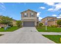 Charming two-story home featuring a two-car garage, well-manicured lawn, and a welcoming front entrance at 5068 Little Stream Ln, Wesley Chapel, FL 33545