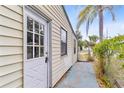 Side view of the home featuring a white door, siding, window, and a glimpse of the backyard at 536 Braddock S St, St Petersburg, FL 33707