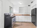 Kitchen with white cabinets, black appliances, wood countertops and modern wood-look flooring at 536 Braddock S St, St Petersburg, FL 33707