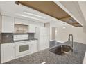 Updated kitchen with sleek granite countertops, white cabinets, and stainless steel sink at 6017 6Th Ave, New Port Richey, FL 34653