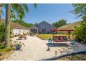 The spacious backyard boasts a cozy seating area, a charming porch swing, and easy-to-maintain landscaping at 7132 Colony Pointe Dr, Riverview, FL 33578