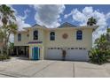 Charming two-story home with a two car garage and decorative sunburst detail under a partly cloudy sky at 9914 Alavista Dr, Gibsonton, FL 33534
