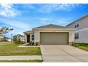 Inviting single-Gathering home featuring a spacious driveway, a two-car garage, and manicured landscaping at 10360 Honeysuckle Vine Cir, Riverview, FL 33578