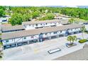 An aerial view of the two-story condo building with covered parking and a lush, green landscape at 1137 King Arthur Ct # 501, Dunedin, FL 34698