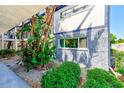 Exterior view of the condo building showcasing the meticulously maintained tropical garden and stone facade at 1137 King Arthur Ct # 501, Dunedin, FL 34698