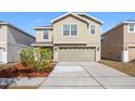 Well-maintained two-story home with a manicured lawn, mature landscaping, and a two-car garage at 12028 Citrus Leaf Dr, Gibsonton, FL 33534