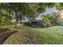 An exterior view of a cozy home surrounded by lush greenery and mature trees at 1211 64Th Nw St, Bradenton, FL 34209