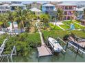 Aerial view of waterfront property with boat dock, manicured yard, and vibrant neighborhood at 1326 Apollo Beach S Blvd, Apollo Beach, FL 33572