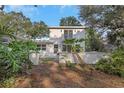 This home includes a fenced backyard, a second-story balcony, and a rear patio at 1905 Pine Tree Ln, Belleair Bluffs, FL 33770