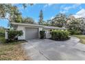 Home featuring a large two-car garage and manicured landscaping at 1905 Pine Tree Ln, Belleair Bluffs, FL 33770