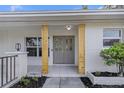 Stylish gray double front door with decorative glass panels and contemporary wood support beams at 1905 Pine Tree Ln, Belleair Bluffs, FL 33770