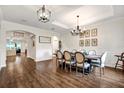Elegant dining room featuring hardwood floors, wainscoting, tray ceiling, and stylish chandelier at 21028 Ski Way, Land O Lakes, FL 34638
