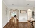Inviting hallway with dark hardwood floors, arched doorways, and views into the living and dining areas at 21028 Ski Way, Land O Lakes, FL 34638