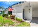 Inviting exterior view showcasing a blue front door, a covered entryway, and beautiful landscaping at 219 80Th Ne Ave, St Petersburg, FL 33702