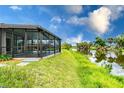 Landscaped backyard features a screened-in patio with scenic waterfront views at 2324 Hayworth Rd, Port Charlotte, FL 33952