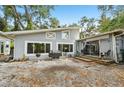 A backyard featuring a gravel groundcover, grill, and a charming house with unique window details at 2507 Mooring Ln, Sarasota, FL 34231