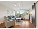 Bright living room featuring hardwood floors, a large window, and stylish furniture at 2615 Cove Cay Dr # 409, Clearwater, FL 33760