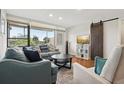 Comfortable living room with a large window, hardwood floors, and a sliding barn door at 2615 Cove Cay Dr # 409, Clearwater, FL 33760